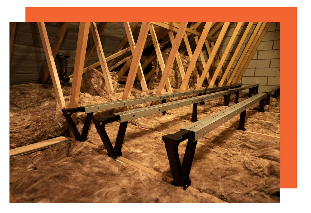 An attic with insulation everywhere and three floor heightening platforms attached to the floor.