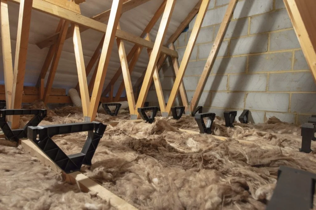 Floor board brackets attached to an attic floor, on top of insulation.