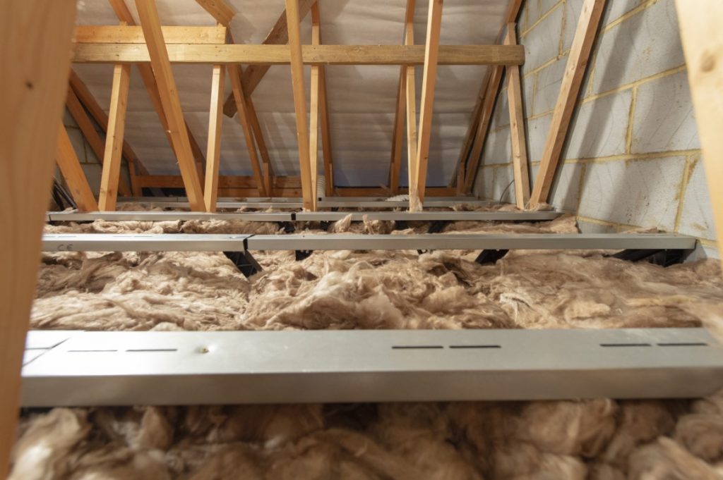 A raised attic floor solution installed into an attic with trusses in the background.