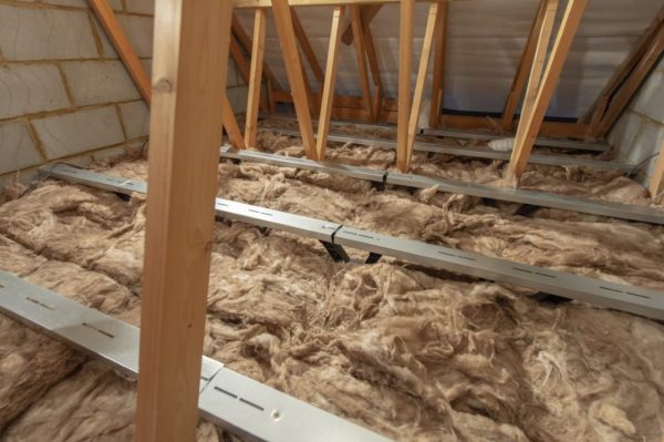 An attic with exposed floor insulation and floor boarding brackets installed.