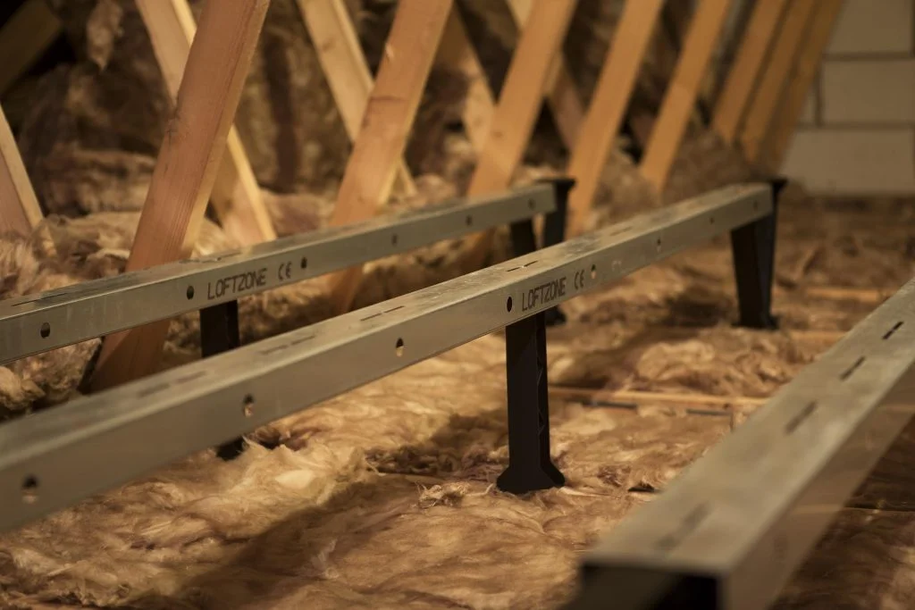 A raised attic flooring system without boards added to showcase the insulation underneath.